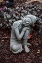 Gray sleeping Buddha sculpture in garden setting