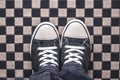 Gray Sneakers on Checkered Pattern Pavement, Top View