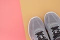 Gray sneakers with a white sole on a beige background.