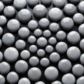 Gray spheres of varying sizes rest on a dark textured surface Royalty Free Stock Photo