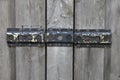 Old rusty hingeson the doors of a gray stable Royalty Free Stock Photo
