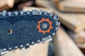 Gray steel chain on a chainsaw tire