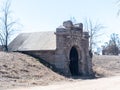 A gray stone mausoleum in winter with blue sky