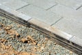 Gray stone pavers installation in progress. Metal edge restraint system, gravel base. Close up
