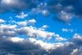 Gray storm clouds gather in the blue sky on a summer day. Several clouds are white Royalty Free Stock Photo