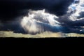 Gray storm clouds through which the rays of the sun