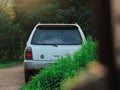 Gray Subaru Forester in green grass and bushes