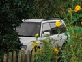 Gray Subaru Forester in green grass and bushes