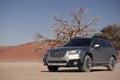 Gray Subaru in the sand of the Namib desert at a bright sky