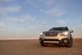 Gray Subaru in the sand of the Namib desert at a bright sky