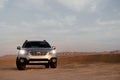 Gray Subaru in the sand of the Namib desert at a bright sky.