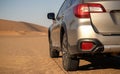 Gray Subaru in the sand of the Namib desert at a bright sky. Namibia