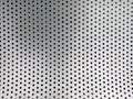 Gray surface with pattern of round black cutout holes, texture, background Royalty Free Stock Photo