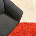 Gray textile armchair on red carpet