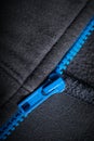 Grey type of cloth that shows the stitching and blue zipper for background