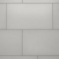 Gray wall with rectangular tiles arranged in a staggered pattern. Each tile has a smoot Royalty Free Stock Photo
