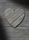 Gray weathered wood heart on wooden background