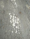 Gray wet asphalt. Damaged asphalt with puddles and stones. Gray routine.