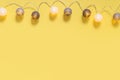 Gray white festive garland on yellow background flat lay top view. Cotton Balls Garland. Round bulbs LED festoon lights electric Royalty Free Stock Photo