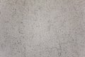 Gray white granular surface of the wall with black dots and a large crack. rough texture Royalty Free Stock Photo