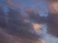 Gray-white thundercloud in a blue sky. Pink sky background at sunset