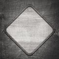 Gray wooden lozenge with frame on dark wall