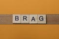 Gray word brag made of wooden square letters