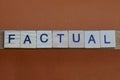 Gray word factual made of wooden square letters