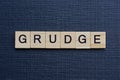 Gray word grudge from small wooden letters