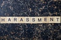 Gray word harassment from wooden letters in black font