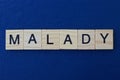 gray word malady in small square wooden letters