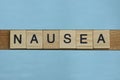 Gray word nausea in small square wooden letters Royalty Free Stock Photo