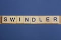 Gray word swindler from small wooden letters