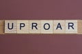 gray word uproar made of wooden square letters