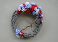 Gray wreath of wicker on a white wall. is decorated with national colors. blue, white, red ribbons and flowers from textile flower Royalty Free Stock Photo