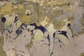 Gray yellow white heavily damaged concrete wall with peeling paint, cracks and purple spots. rough surface texture Royalty Free Stock Photo