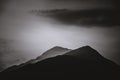 Grayscale beautiful shot of mountain scenery and skyscape in a foggy weather