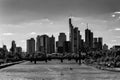 Grayscale beautiful view of a river with bridge and skyscrapers in a background