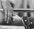 Grayscale closeup of daughter holding father`s hand