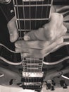 Grayscale closeup of a man's hand holding an electric guitar
