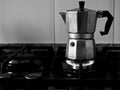 Grayscale closeup shot of a moka pot on a stove