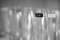 Grayscale closeup shot of a row of Krosno brand wine glasses in a cupboard