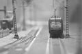 Grayscale closeup of a small train toy on the railroad against the blurry background.