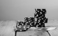 Grayscale closeup of a stack of poker chips on the table