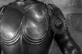 Grayscale closeup of the upper part of the armor of a medieval knight.