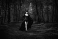 Grayscale of a gothic girl with Maleficent horns walking in a mystic forest Royalty Free Stock Photo
