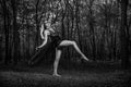 Grayscale of a gothic young girl in black transparent dress posing in a forest Royalty Free Stock Photo