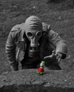 Grayscale of a male in a gas mask reaching to a toy