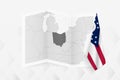 A grayscale map of Ohio with a hanging Ohio flag on one side. Vector map for many types of news