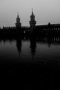 Grayscale of The Oberbaum Bridge crossing Berlin's River Spree reflected in the water